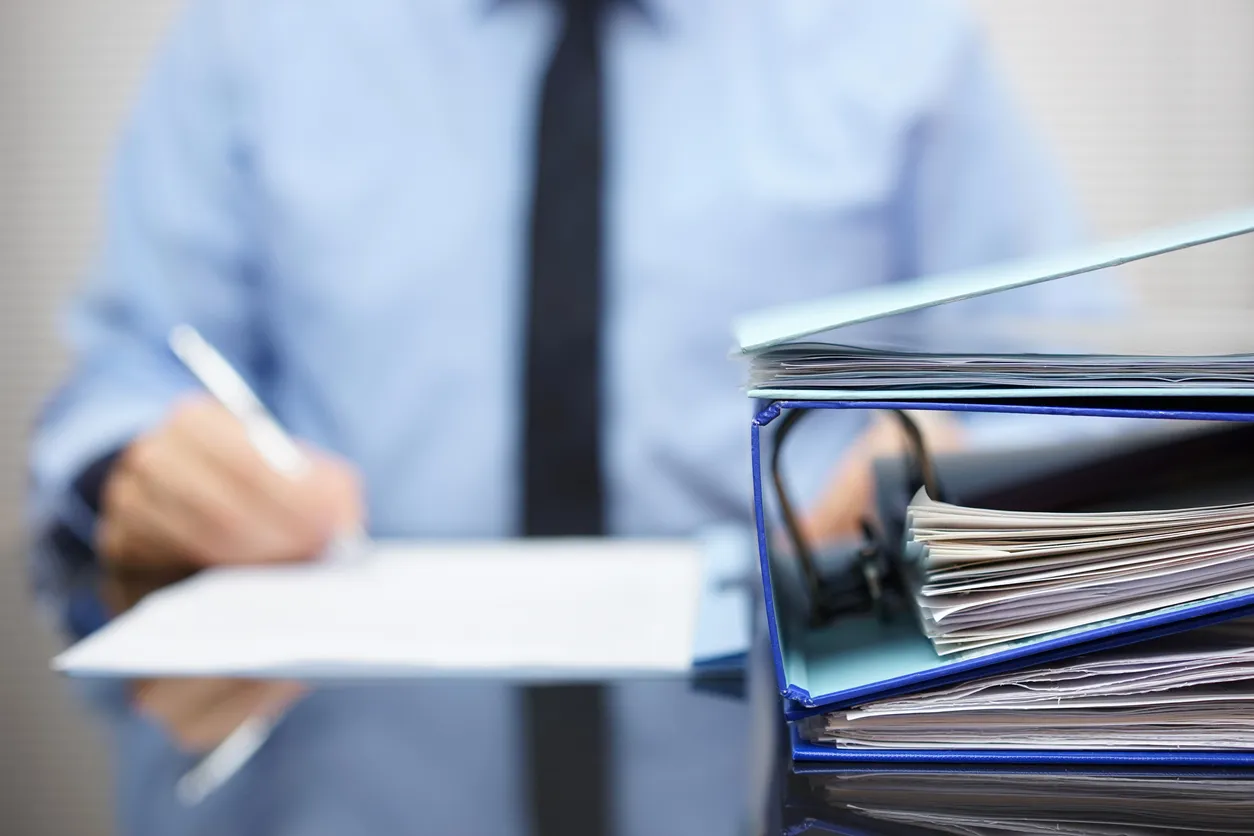 Office desk with documents and laptop representing CPS 234 compliance work for Australian insurance brokers