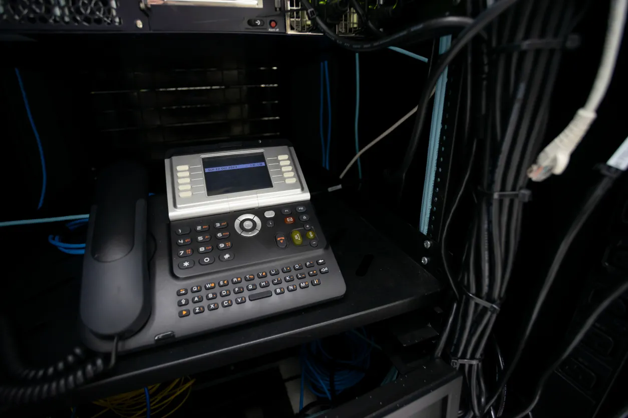 Cloud-hosted phone system represented by a desk phone and server cabinet in a Sydney office