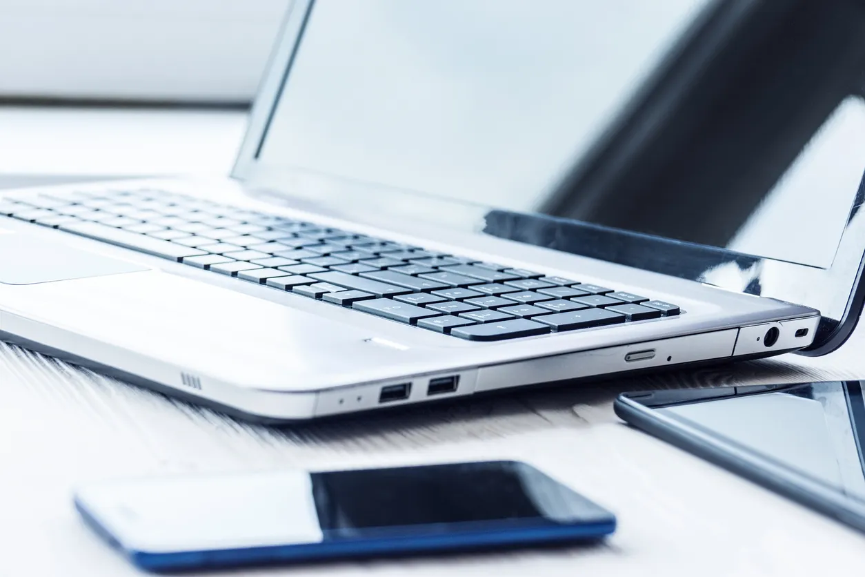 Laptop and mobile device on an office desk representing Microsoft Intune device management for Australian SMEs