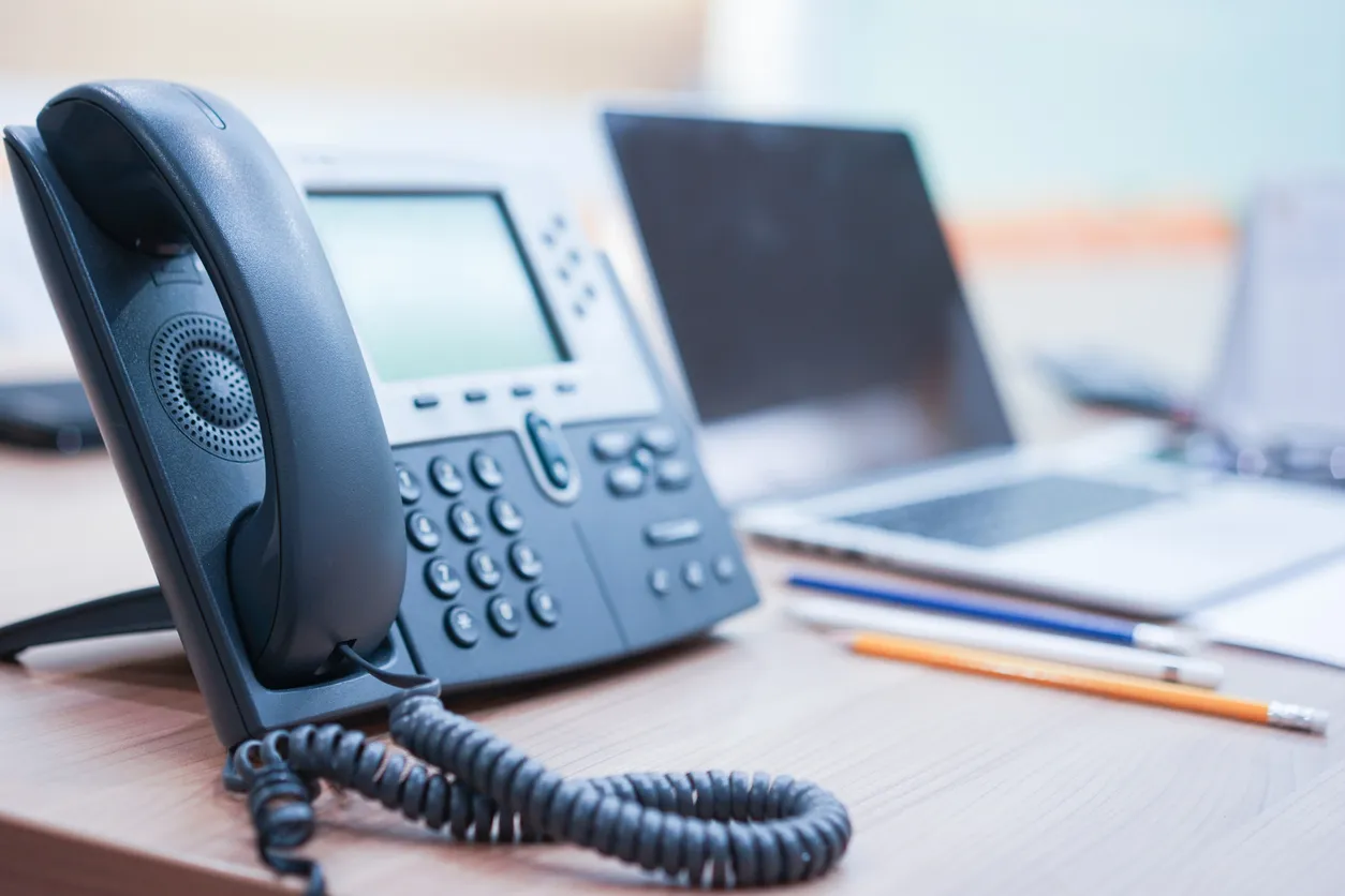 VoIP desk phone and laptop on a Sydney office desk