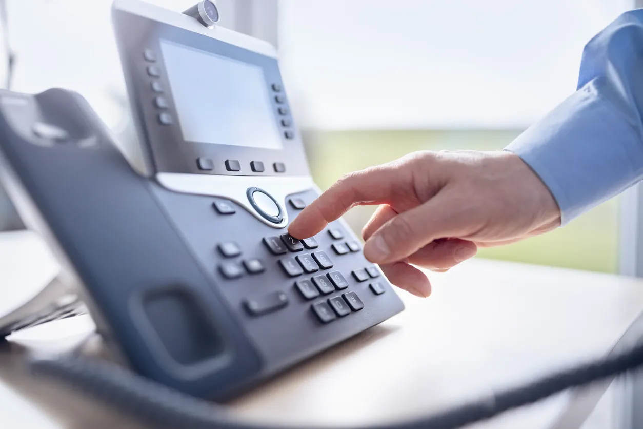 A traditional desk phone beside a modern IP phone on a Sydney office desk