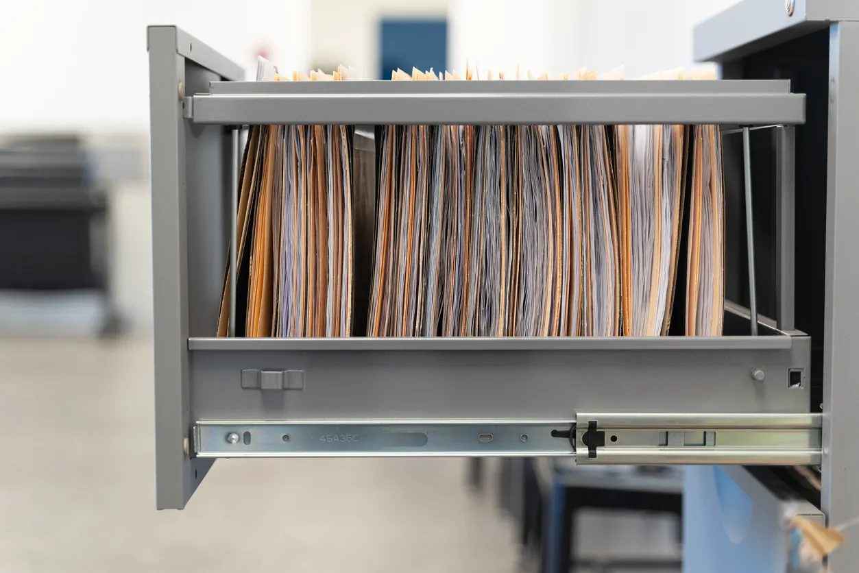 Office desk with documents and laptop representing ISMS documentation and ISO 27001 work for Australian SMEs