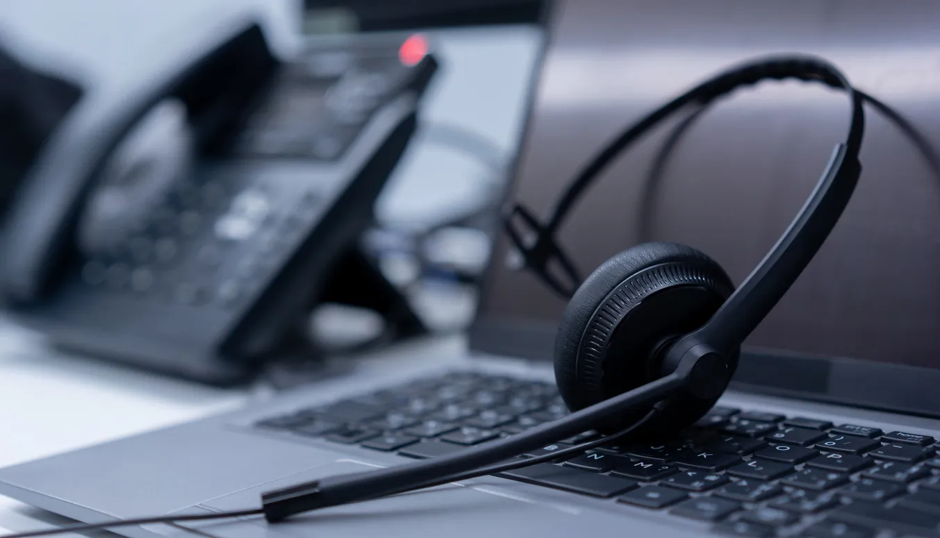 Desk phone connected to a laptop on a Sydney office desk representing VoIP