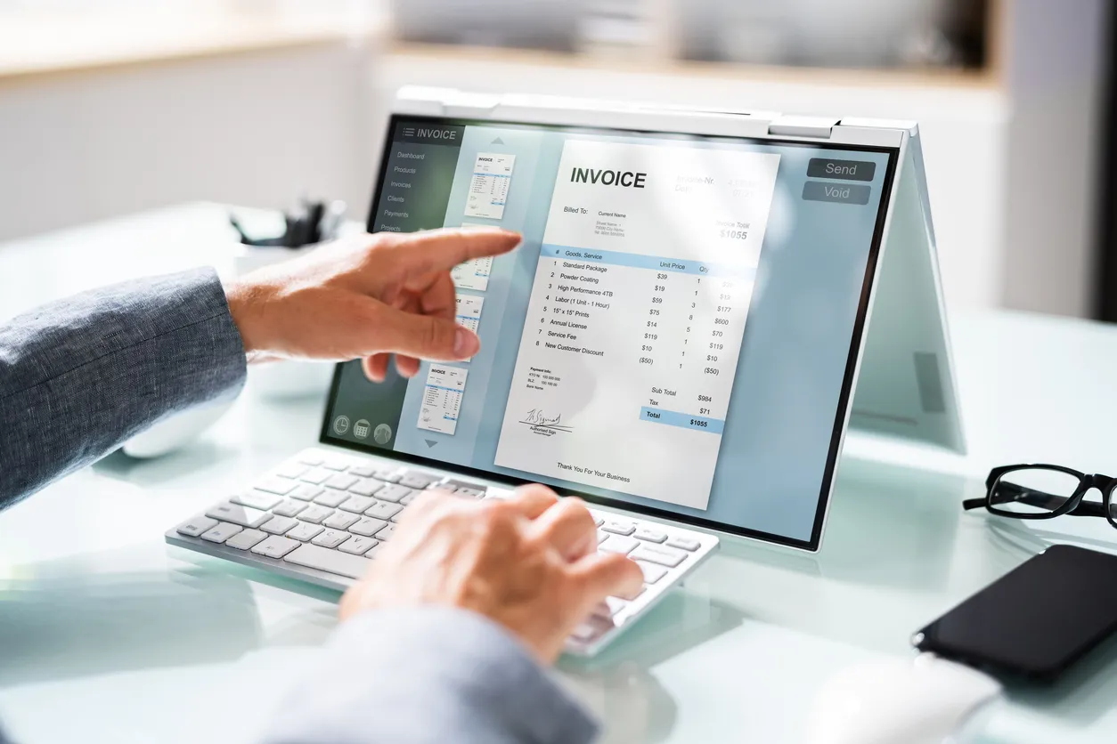 Automated invoice and document workflow moving between screens on an office desk