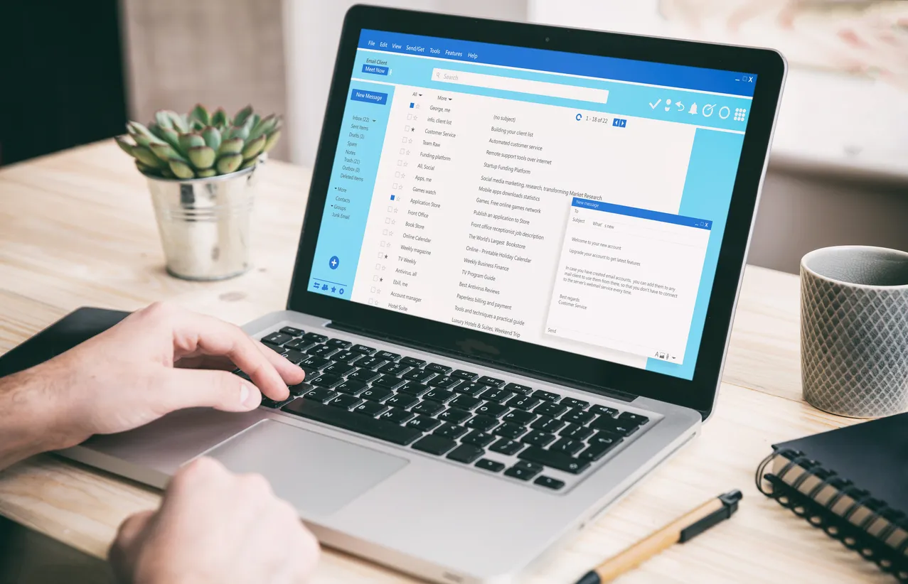 Laptop showing an email inbox with authentication settings on screen