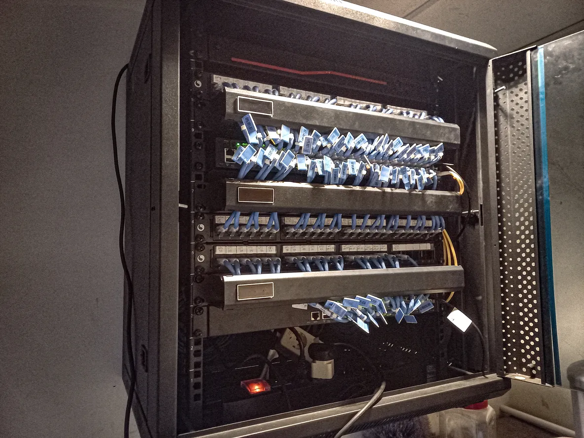 Rack-mounted business firewall appliance in a network cabinet with patch cabling.