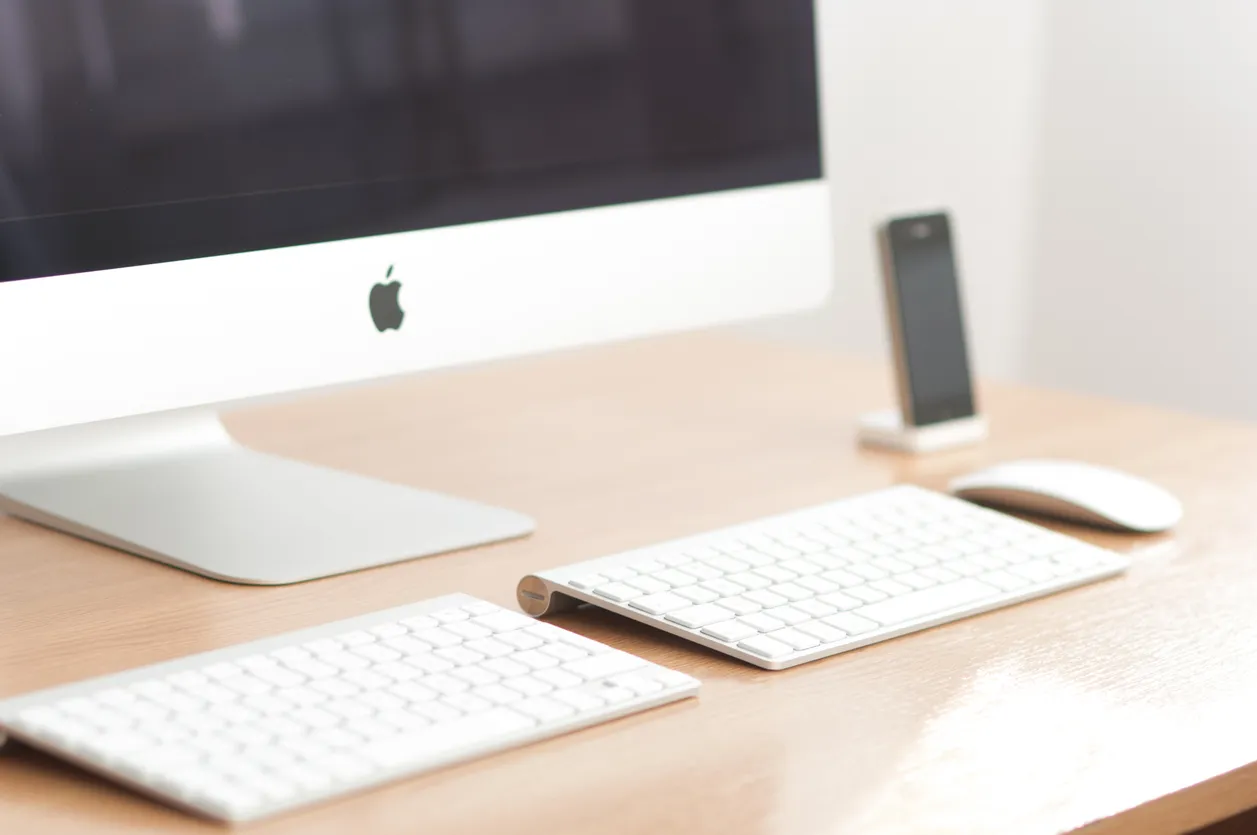 Mac desktop computer on an office desk showing a mail application.