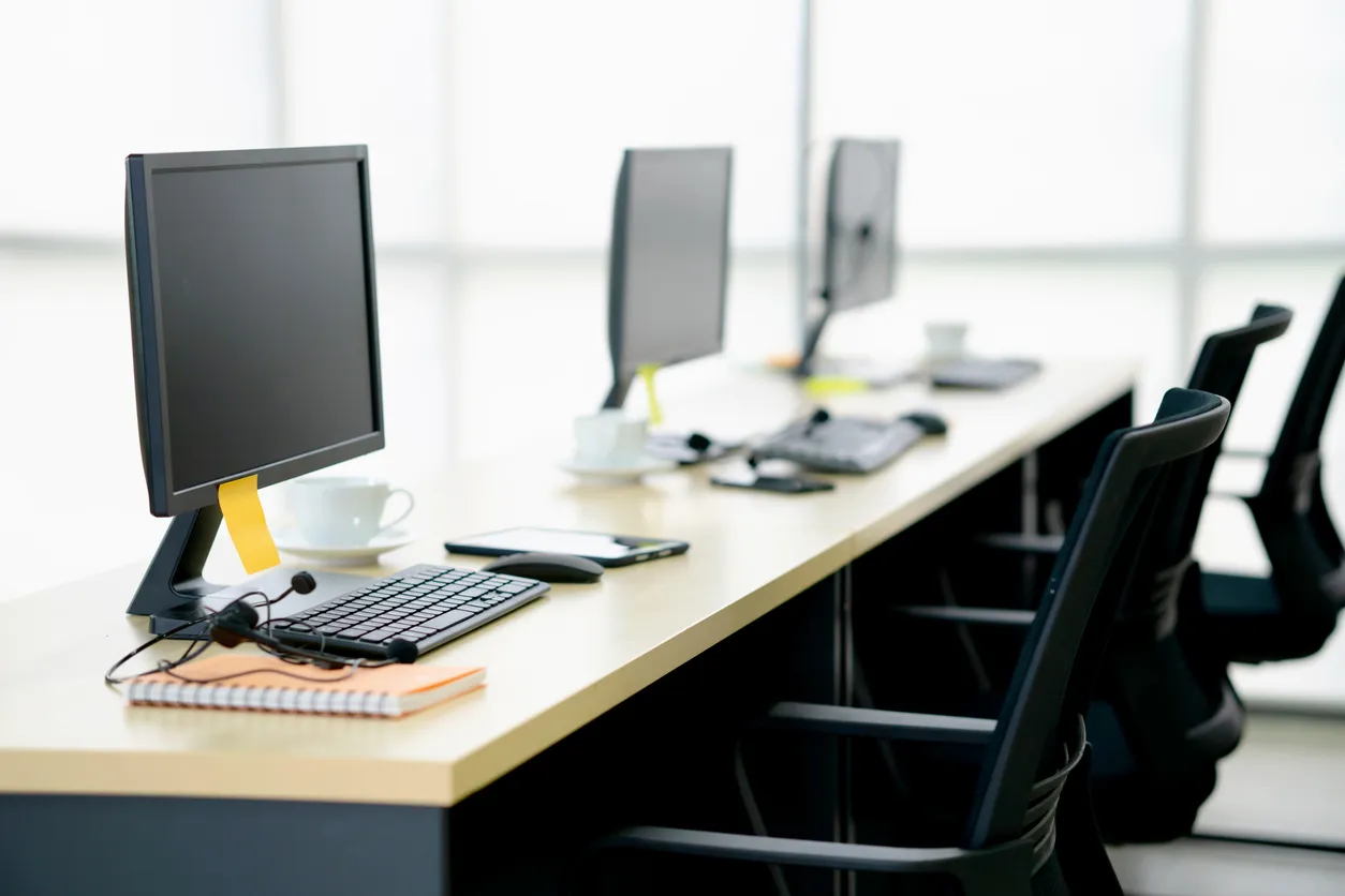 Row of desktop computers in an office due for software updates.