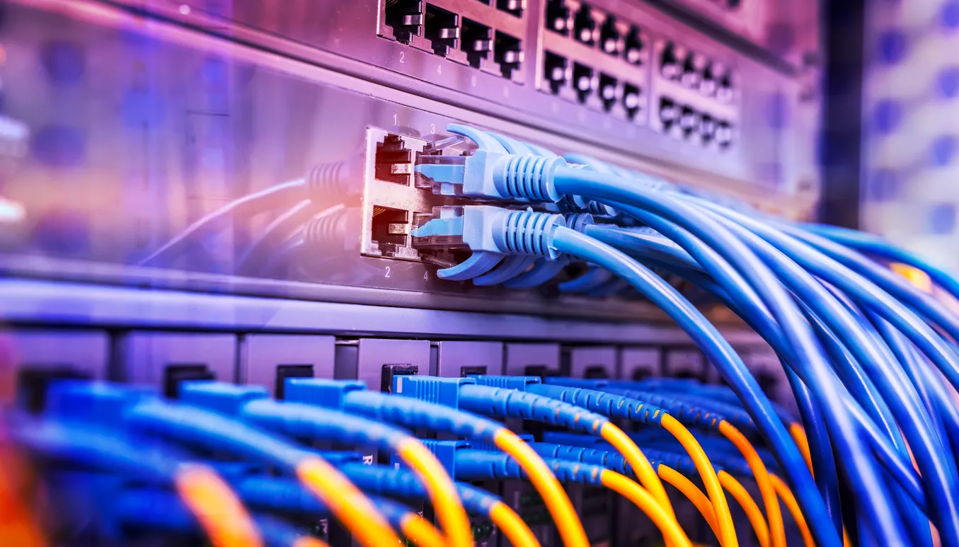 Network switch and router mounted in an office comms cabinet with cabling