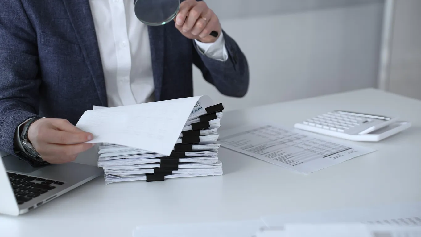 Clipboard with an audit checklist beside a laptop on an office desk