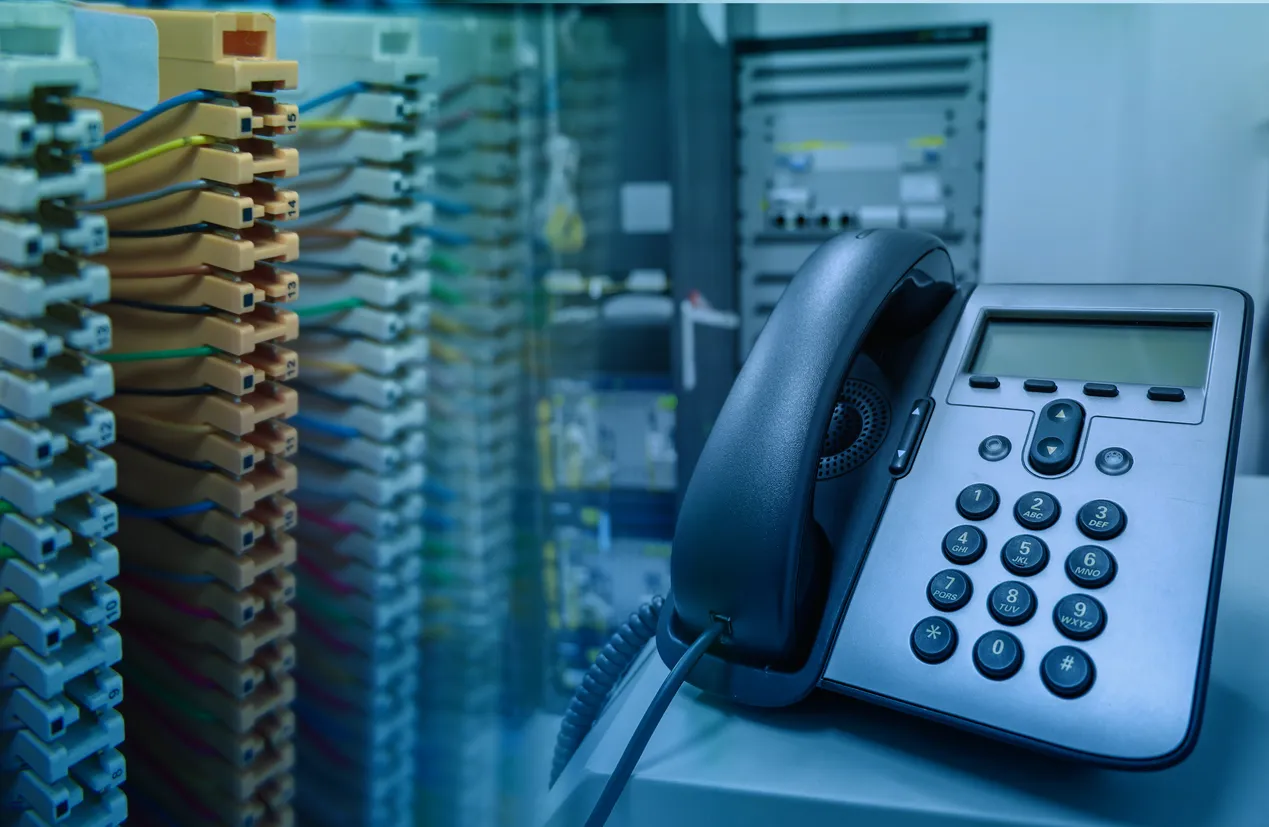 VoIP desk phone connected to an office network switch, illustrating calls over the internet.