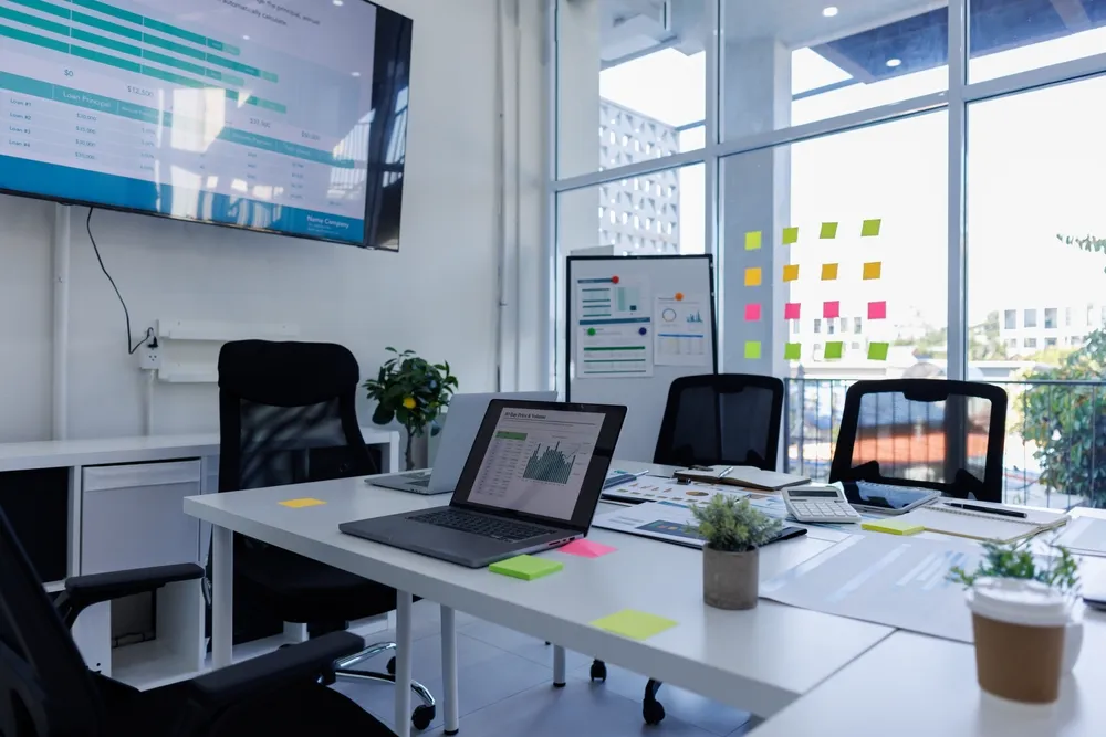 Business laptops and compact desktop PCs set up at an office workstation.