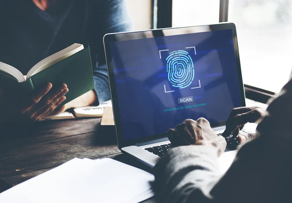 Person unlocking a laptop sign-in using a fingerprint sensor.