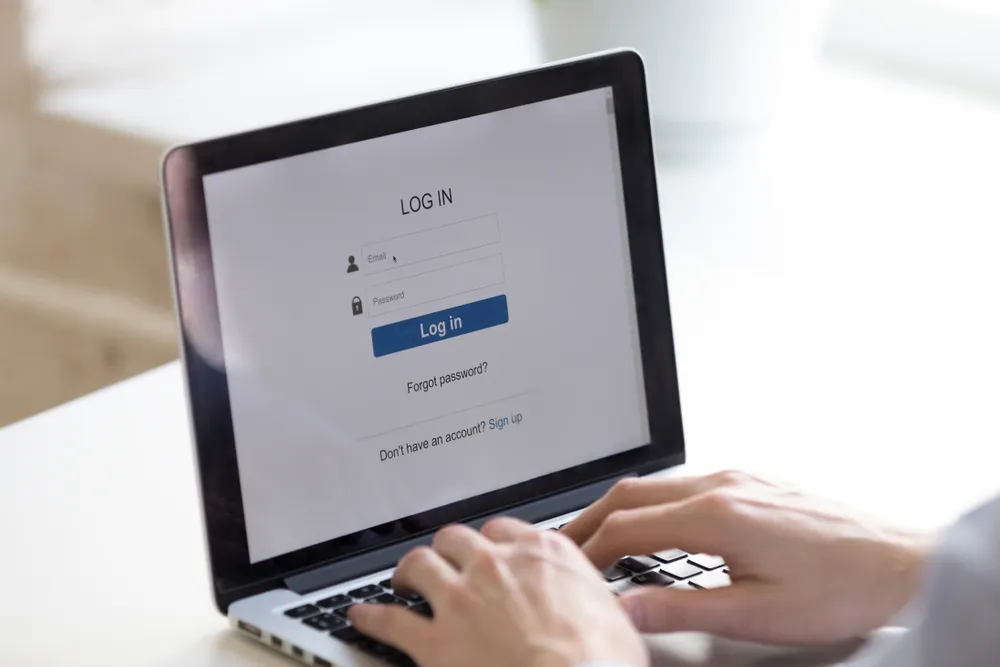Office worker signing in to a business system on a laptop.