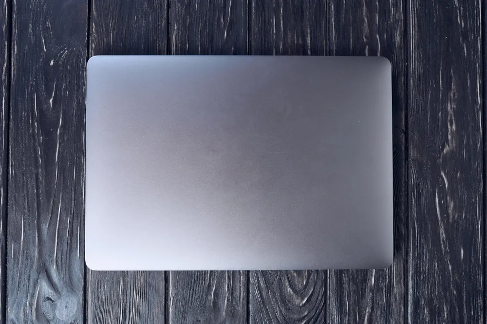 Closed MacBook on an empty desk in an office