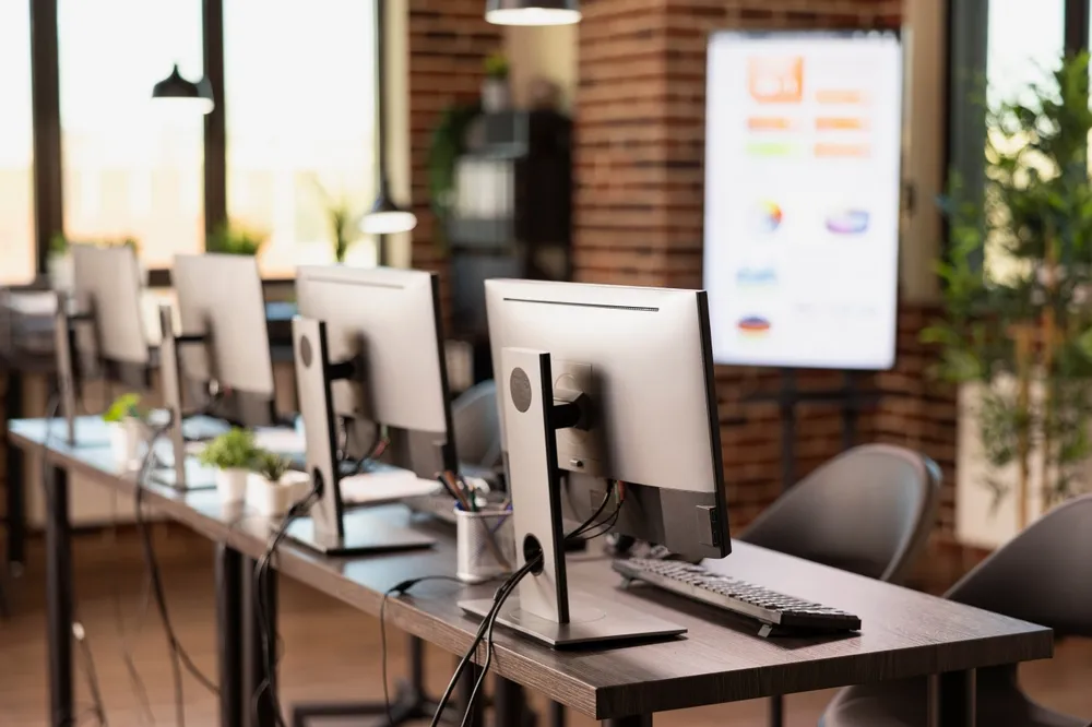 Laptop and desktop computer on an office desk beside a network switch