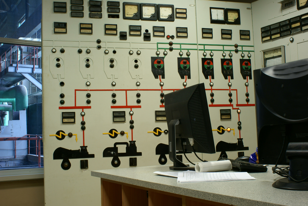 Older desktop computer and industrial control panel in a workshop