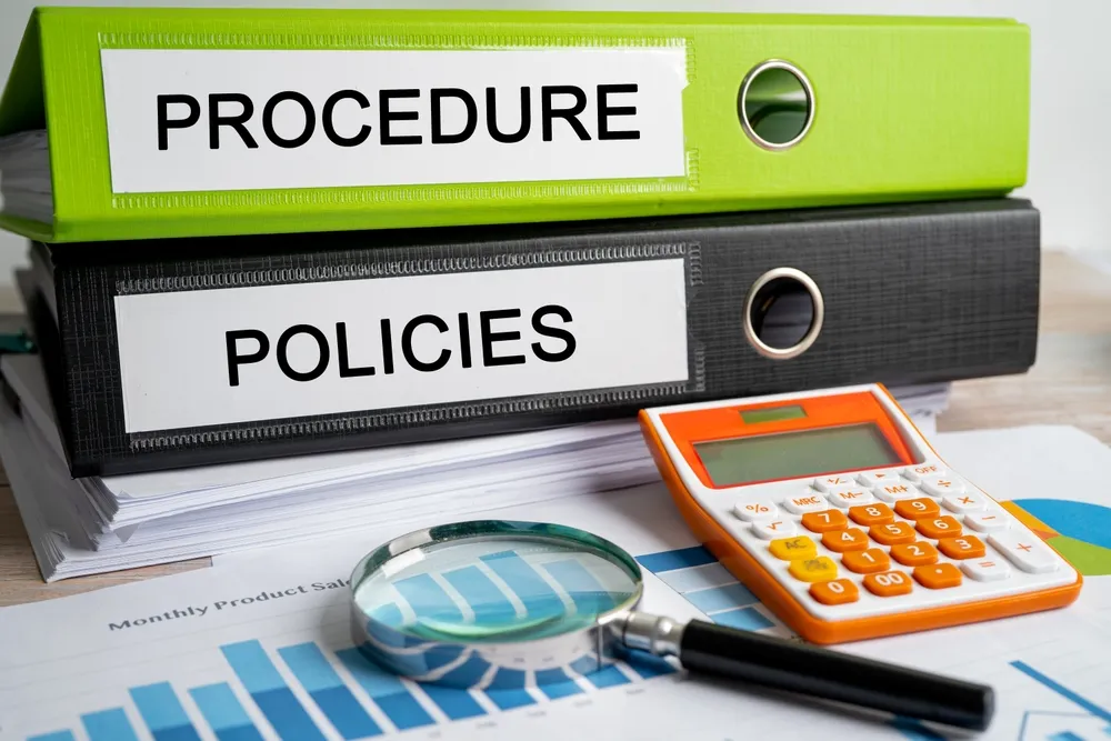 Printed policy documents in a folder on an office desk