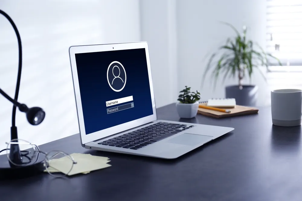 MacBook showing a sign-in screen on an office desk