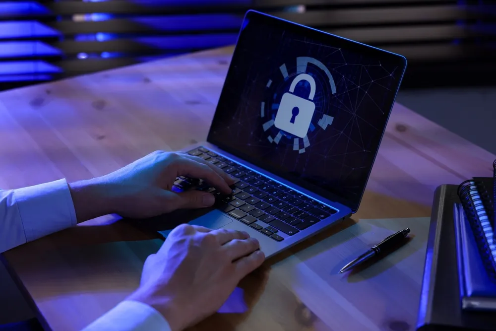 IT administrator configuring security settings on a laptop in an office.