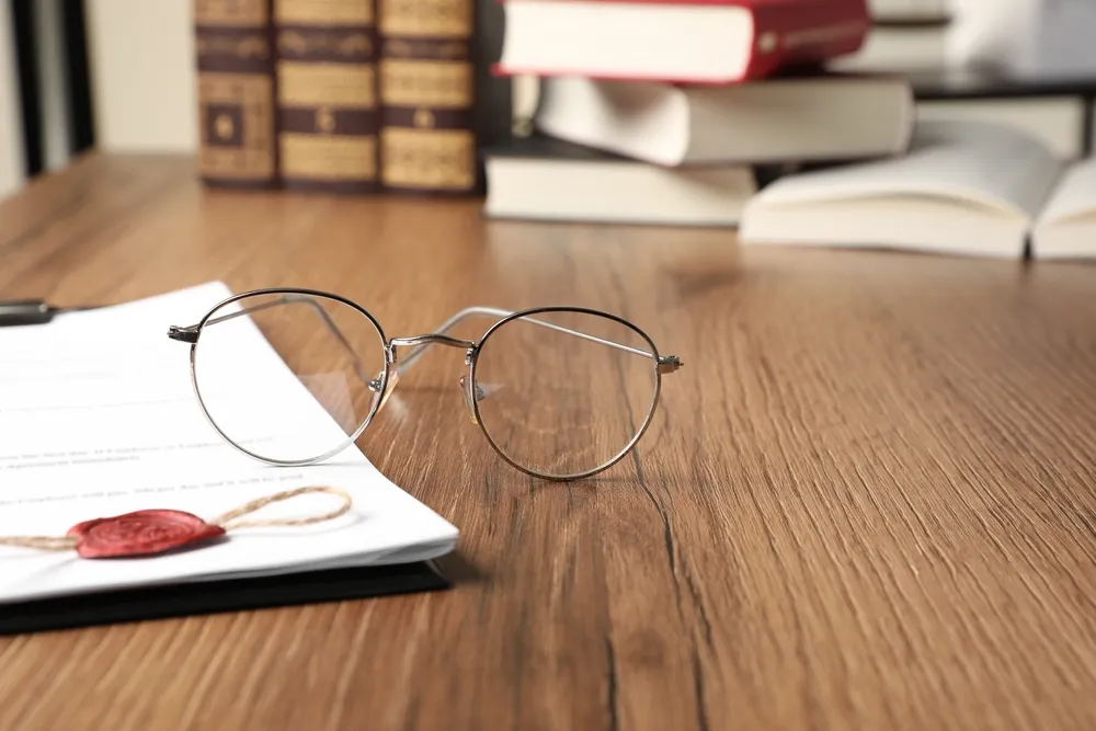 Australian legislation documents and reading glasses on a desk