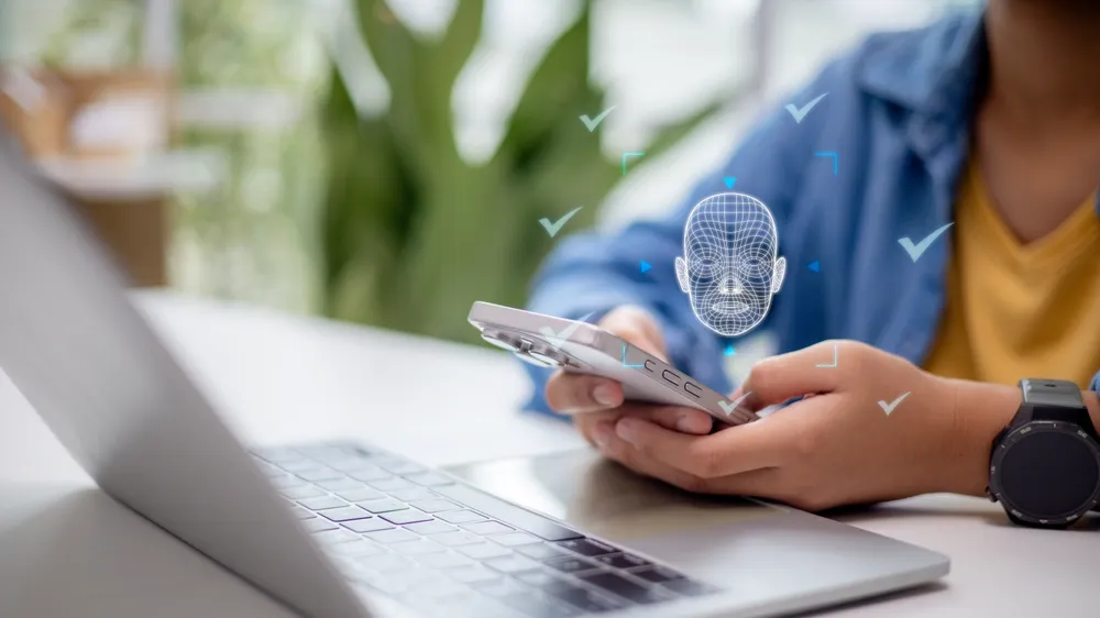 Person signing in to a Windows laptop using facial recognition in an office.