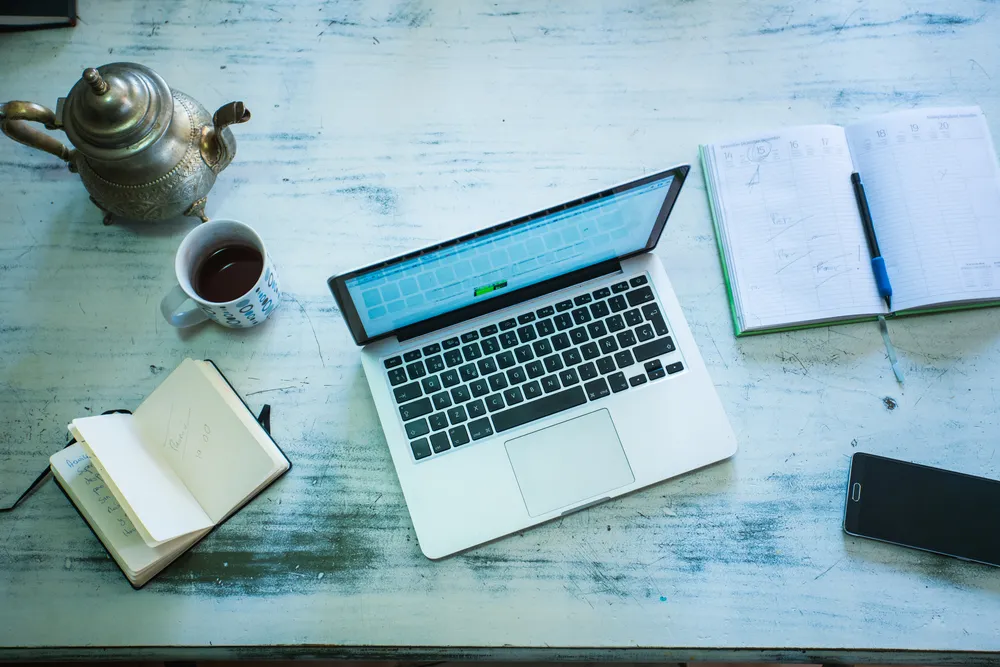 Open notebook and laptop on a meeting room table.